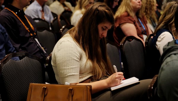 An attendee taking notes