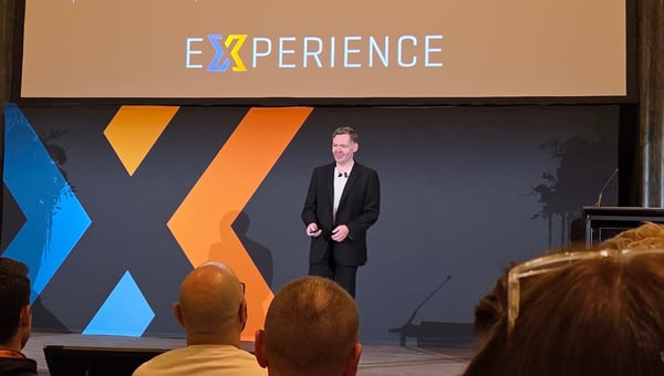 Configura CEO Steven Jenkins speaking on stage in front of the Experience logo