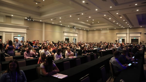 Attendees begin to file in… The air is heavy with anticipation