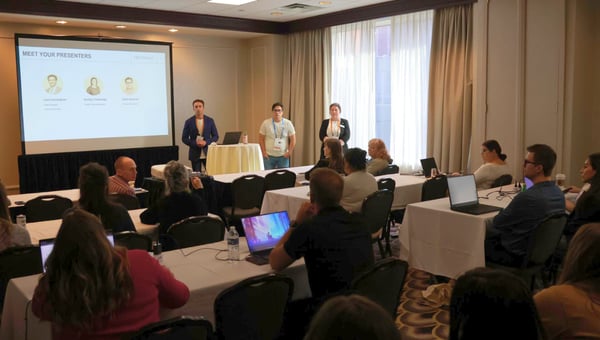 Attendees at a hands-on workshop following along as presenters lead from the front of the room