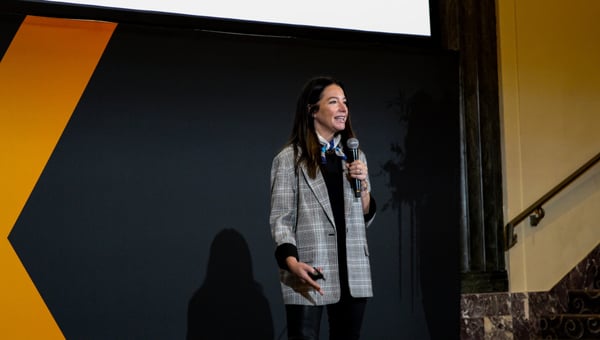 Ali Oxley of OFS presenting on stage with a microphone