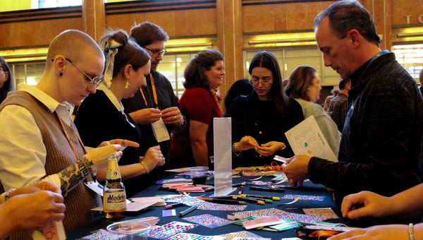 Attendees decorating their name badges at a table covered in craft supplies [Photo: group with dinosaur skeletons]