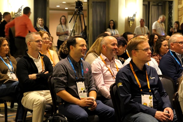 Keynote audience members laughing and applauding in their seats