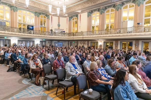 A full audience seated in the Hall of Mirrors beneath its gilded balconies